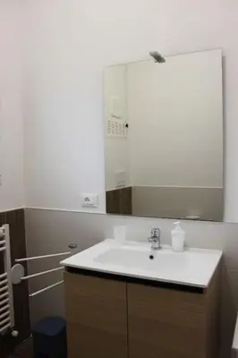 a bathroom with a white sink and a mirror at Zia Pina Home in Palermo