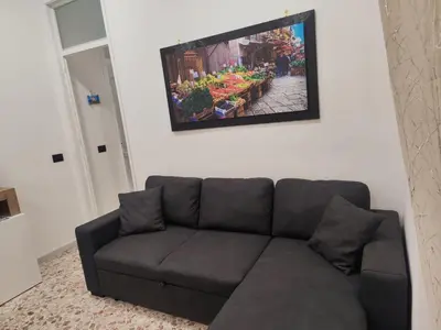 a couch in a living room with a tv on the wall at Casa Donna Caterina e Don Paolo in Bagheria