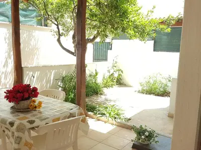 a table and chairs with a table and flowers on it at Casa Limone in San Vito lo Capo