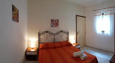 a bedroom with a large bed with a red blanket at Casa Limone in San Vito lo Capo