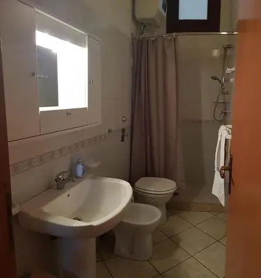 a bathroom with a sink and a toilet and a window at Casa Limone in San Vito lo Capo