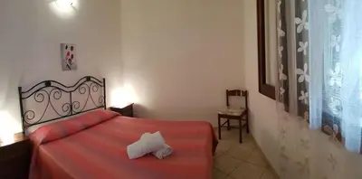 a bedroom with a red bed with a white pillow on it at Casa Limone in San Vito lo Capo