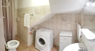a bathroom with a toilet a sink and a washing machine at Casa Limone in San Vito lo Capo