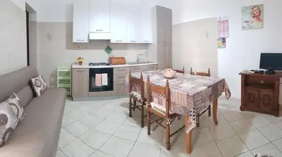 a kitchen with a table and a kitchen with a couch at Casa Limone in San Vito lo Capo