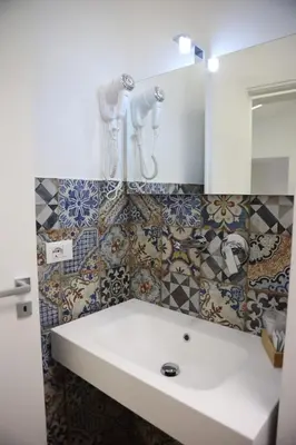 a bathroom with a sink and a mirror and tiles at Palermo Centro Affittacamere Spina in Palermo