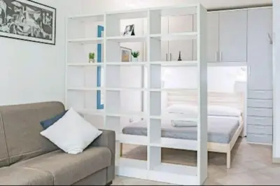 a living room with a bed and a white book shelf at Cappellieri Home in Palermo