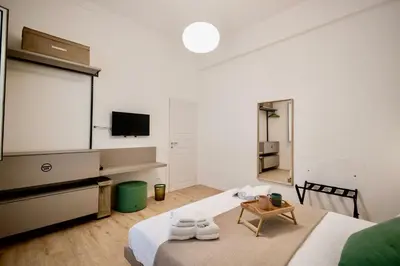 a white room with a bed and a tv at Politeama Charming Apartment in Palermo