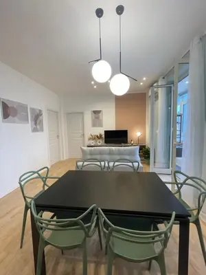 a dining room with a black table and chairs at Politeama Charming Apartment in Palermo