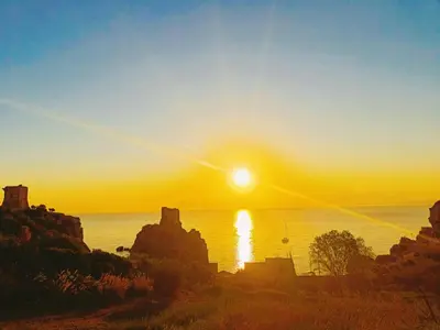 a view of the sun setting over the ocean at Where The Sun Rises in Scopello