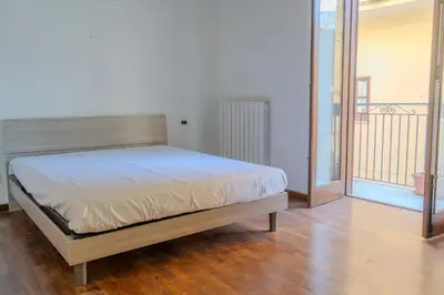 a bedroom with a bed in a room with a balcony at La discesa di San Giuseppe in Termini Imerese