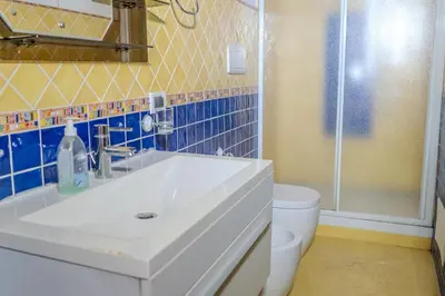 a bathroom with a white sink and a shower at La discesa di San Giuseppe in Termini Imerese