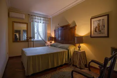 a bedroom with a bed and a chair in a room at Palermo 3 bedrooms apartment historic center in Palermo