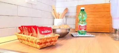 a basket of bread and a bottle of soda on a counter at Casa Grazia in Palermo
