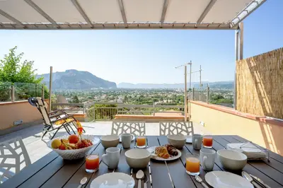 a table with a bowl of fruit and a bowl of juice at Lollo's Terrace Panoramic View in Palermo
