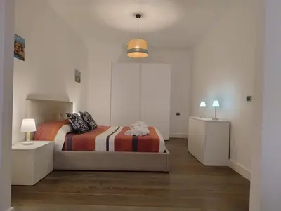 a bedroom with a bed and two night stands at Lollo's Terrace Panoramic View in Palermo