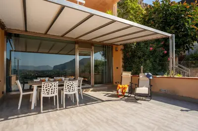 a patio with a table and chairs on a balcony at Lollo's Terrace Panoramic View in Palermo