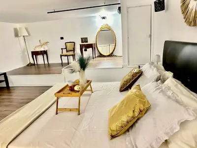 a white bed with gold pillows and a table at Siloe Apartment Palermo in Palermo