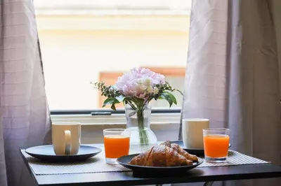 a table with a vase of flowers and orange juice at 200 mt Quattro Canti- Appartamento Rovere in Palermo