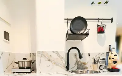 a kitchen counter with a sink and a skillet at 200 mt Quattro Canti- Appartamento Rovere in Palermo