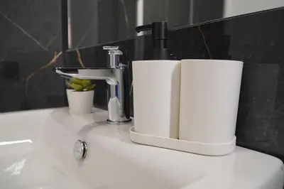 a bathroom sink with a faucet and two cups on it at 200 mt Quattro Canti- Appartamento Rovere in Palermo