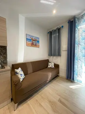 a living room with a brown couch in a room at La Casetta di Isola in Isola delle Femmine