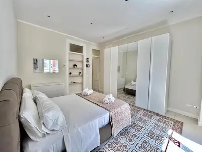 a white bedroom with a bed and a couch at Casa Esterù -Centro storico di Palermo- in Palermo