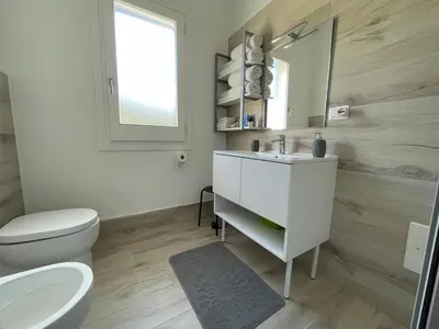 a bathroom with a sink and a toilet and a mirror at La Dolce Vita in Campofelice di Roccella