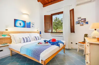 a bedroom with a bed with a tray of food on it at Villa Brezza Marina - Scopello-Villas in Scopello