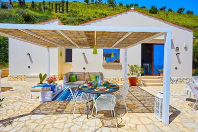 a patio with a table and chairs under a pergola at Villa Brezza Marina - Scopello-Villas in Scopello