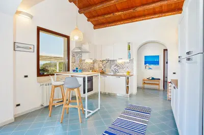 a kitchen with white cabinets and a blue tile floor at Villa Brezza Marina - Scopello-Villas in Scopello