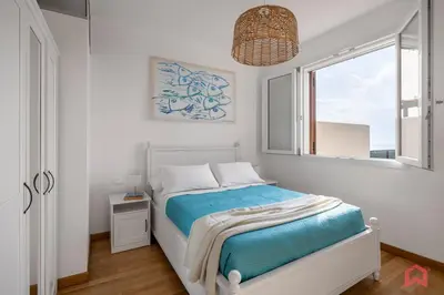 a white bedroom with a bed with a window at Villa with Sea view Private Pool in Terrasini