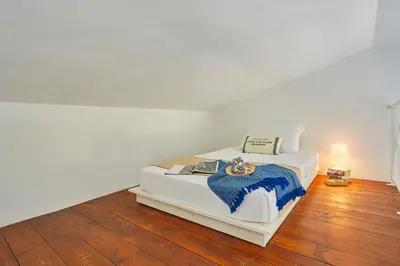 a white bed with a watch on top of it at Villa Desirée - Scopello-Villas in Scopello