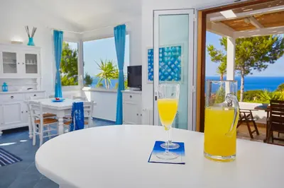 a table with two glasses of orange juice on it at Villa Desirée - Scopello-Villas in Scopello