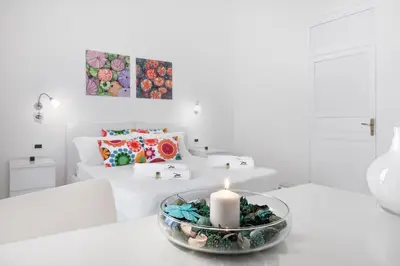 a white living room with a candle on a table at Room & Breakfast Zero in Palermo