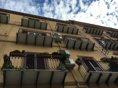 a building with windows and balconies with plants on it at Room & Breakfast Zero in Palermo
