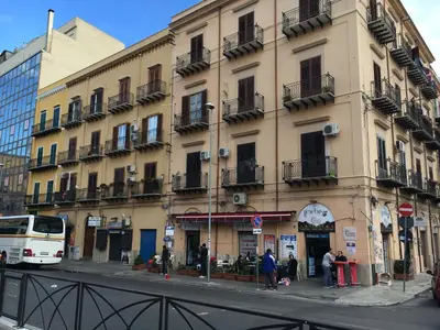 a building on the corner of a city street with a bus at Room & Breakfast Zero in Palermo