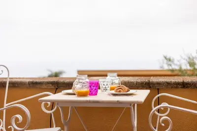 a small white table with two jars of orange juice at Villa Carmen in Mandra Capreria
