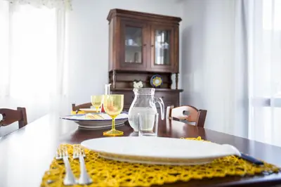 a dining room table with a plate and wine glasses at Appartamento La Marina in Castellammare del Golfo