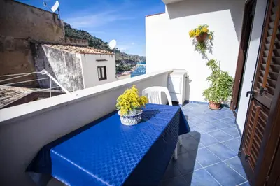 a blue table on a balcony with flowers on it at Appartamento La Marina in Castellammare del Golfo
