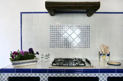 a kitchen with a stove and a blue and white tile wall at Appartamento La Marina in Castellammare del Golfo