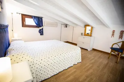 a bedroom with a white bed and a window at Appartamento La Marina in Castellammare del Golfo