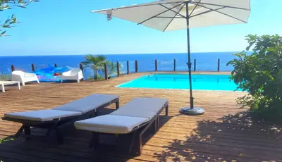 a pool with an umbrella and chairs and a table at Il Casale San Vito in San Vito lo Capo