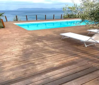 a swimming pool with a bench on a wooden deck at Il Casale San Vito in San Vito lo Capo