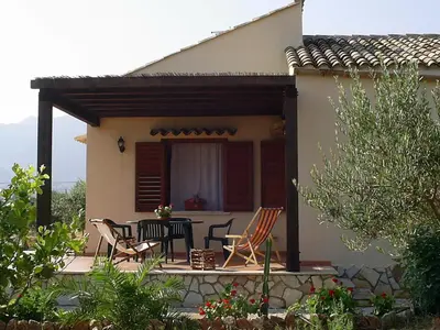 a patio with chairs and a table in front of a house at Villa Chiara in Scopello