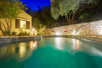 a swimming pool in front of a house at night at Villa Del Sol - Scopello-Villas in Scopello