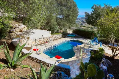 a pool with chairs and an umbrella in a yard at Villa Del Sol - Scopello-Villas in Scopello