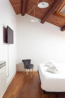 a bedroom with a bed and a chair at Vittorio Emanuele Suite Apartment in Palermo
