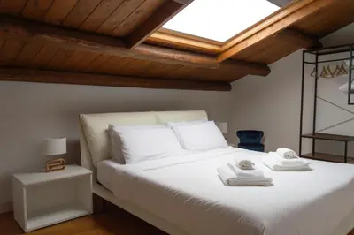 a bedroom with a white bed with towels on it at Vittorio Emanuele Suite Apartment in Palermo
