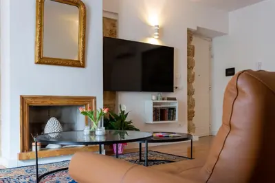 a living room with a table and a tv at Vittorio Emanuele Suite Apartment in Palermo