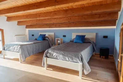 two beds in a room with wooden ceilings at Villa Michela - Dimora di Charme a Cefalù con panorama sul mare by CEFALU BIZ in Cefalù